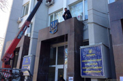 Вооруженные ломами люди демонтируют государственные символы в Севастополе. ФОТО