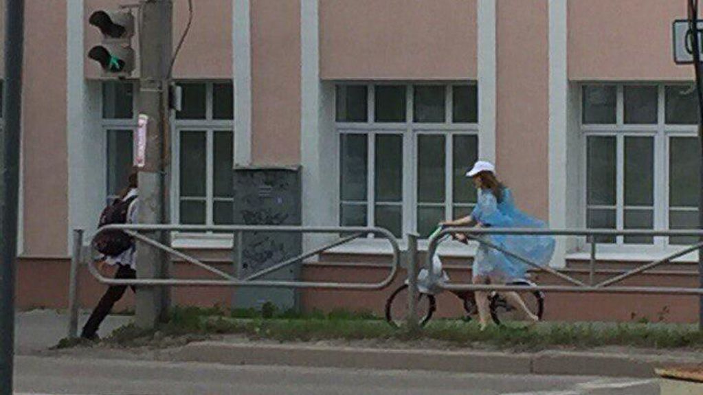 Голая россиянка в прозрачном дождевике прокатилась на велосипеде по улицам