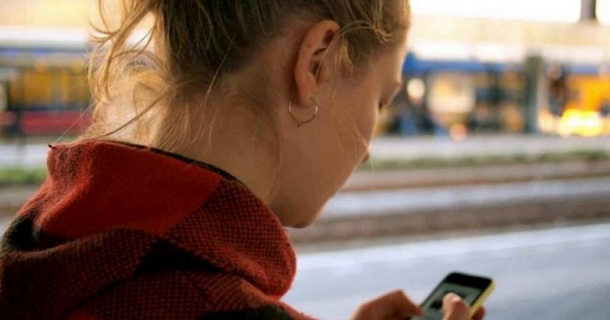 смотрит в телефон